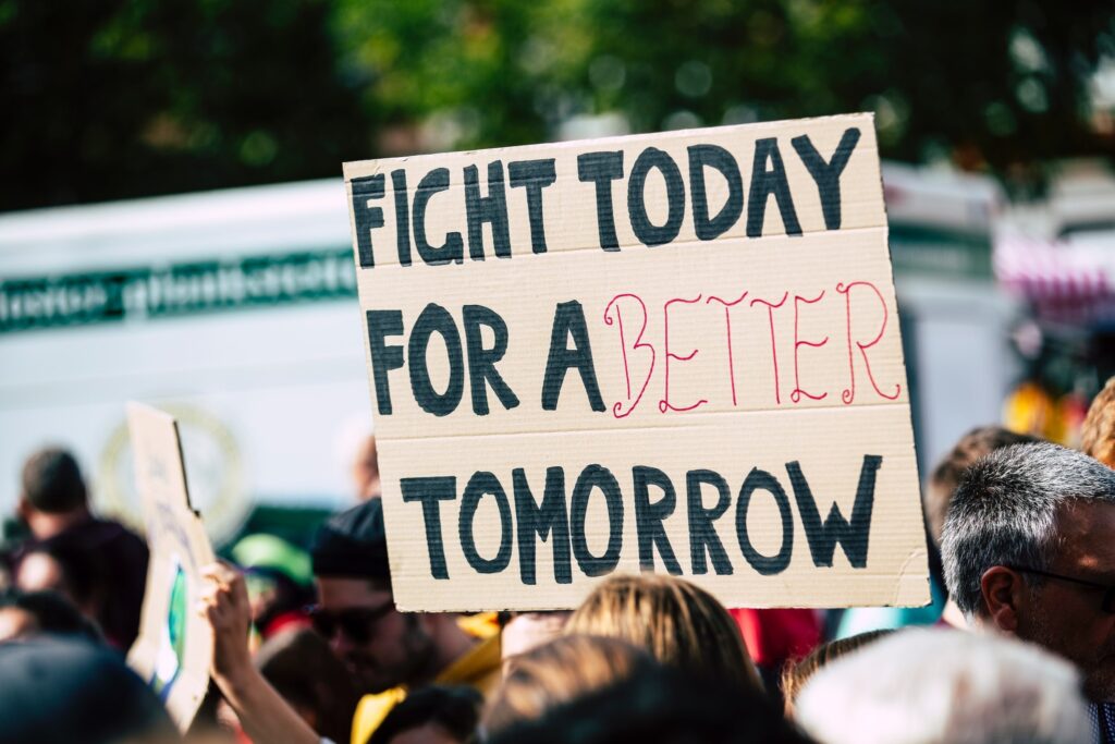 Auf diesem Bild ist die Menschenmenge auf einer Demonstration zu sehen. Auf einem Schild steht: Fight Today for a better tomorrow.